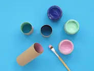Toilet roll tube painted with colourful paints and a paint brush
