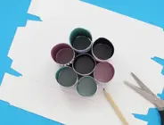 Paper tubes wrapped in wrapping paper and glued together side by side, on a flattened tissue box base.